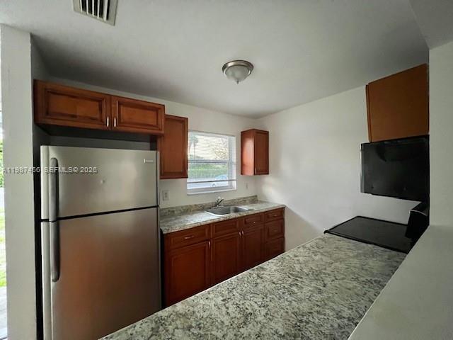 A kitchen features wood cabinets, stainless steel appliances, and a granite countertop — 2746 Johnson St # w, Hollywood FL 33020, HOLLYWOOD, FL