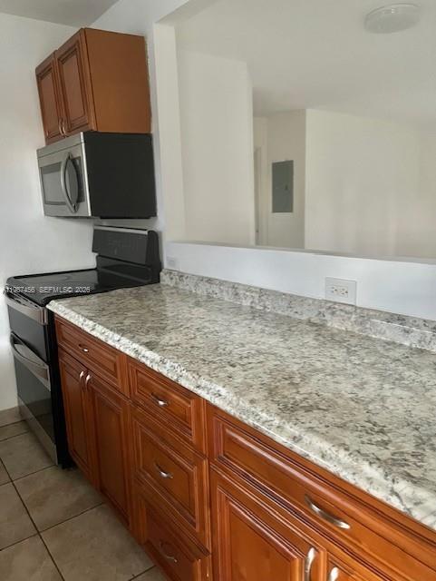 A kitchen features wood cabinets, granite countertops, and a black microwave and stove — 2746 Johnson St # w, Hollywood FL 33020, HOLLYWOOD, FL