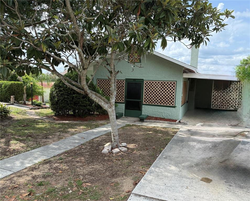 A light green house with a front porch, lattice accents, and a concrete driveway — 534 W OSCEOLA STREET, CLERMONT, FL