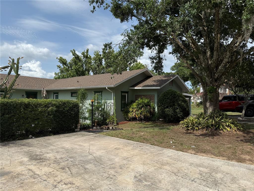 A single-story house with a light green exterior, a concrete driveway, and a large tree — 534 W OSCEOLA STREET, CLERMONT, FL
