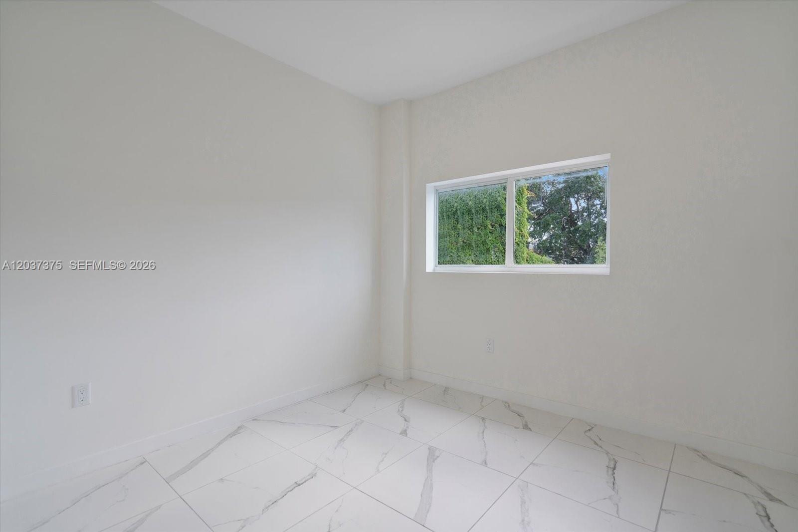 An empty room features white walls, white marble-patterned tile flooring, and a single window — 420 SW 7th Ave # 201, Miami FL 33130, MIAMI, FL