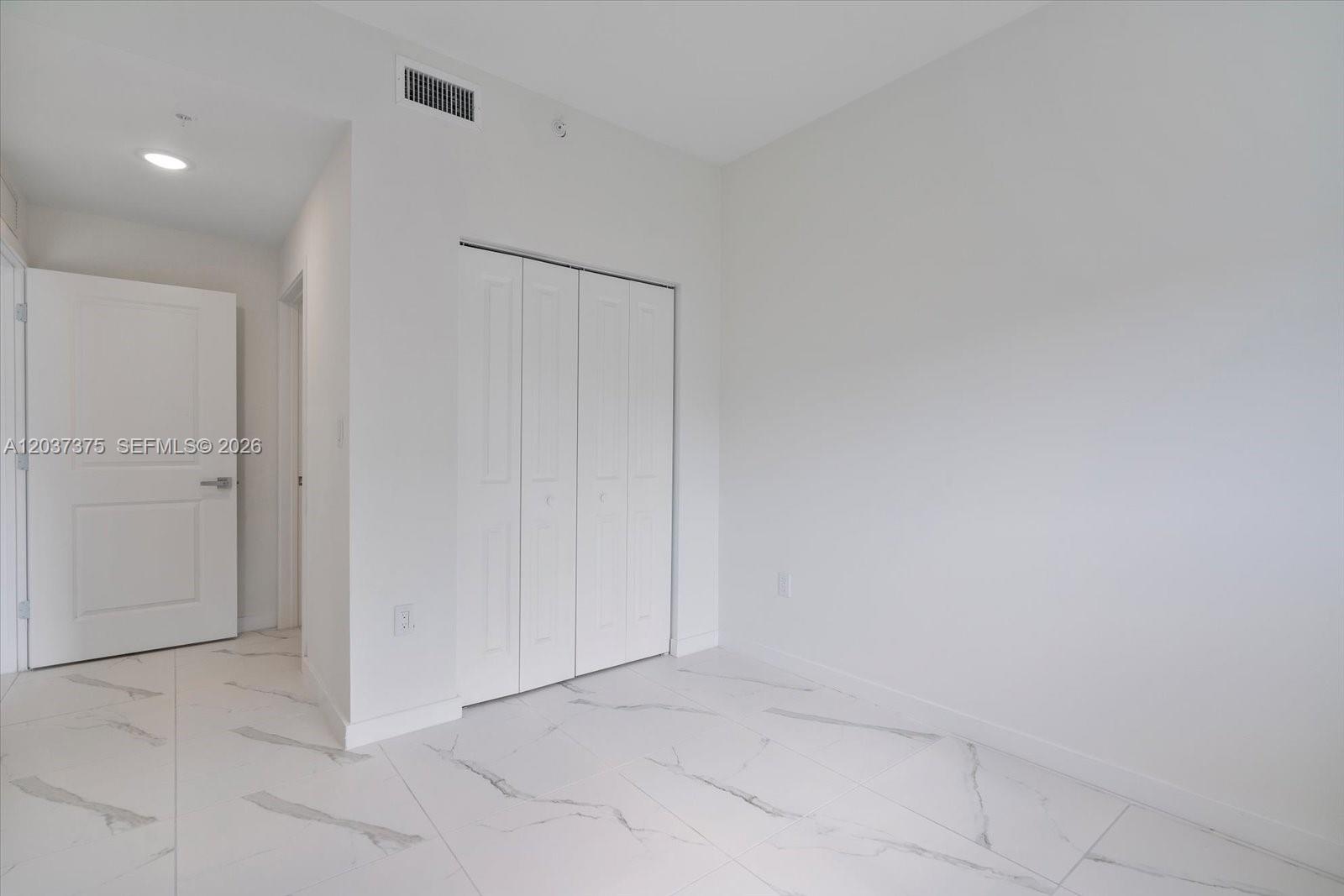 A room with white walls, white marble-patterned tile flooring, and a white bi-fold closet — 420 SW 7th Ave # 201, Miami FL 33130, MIAMI, FL
