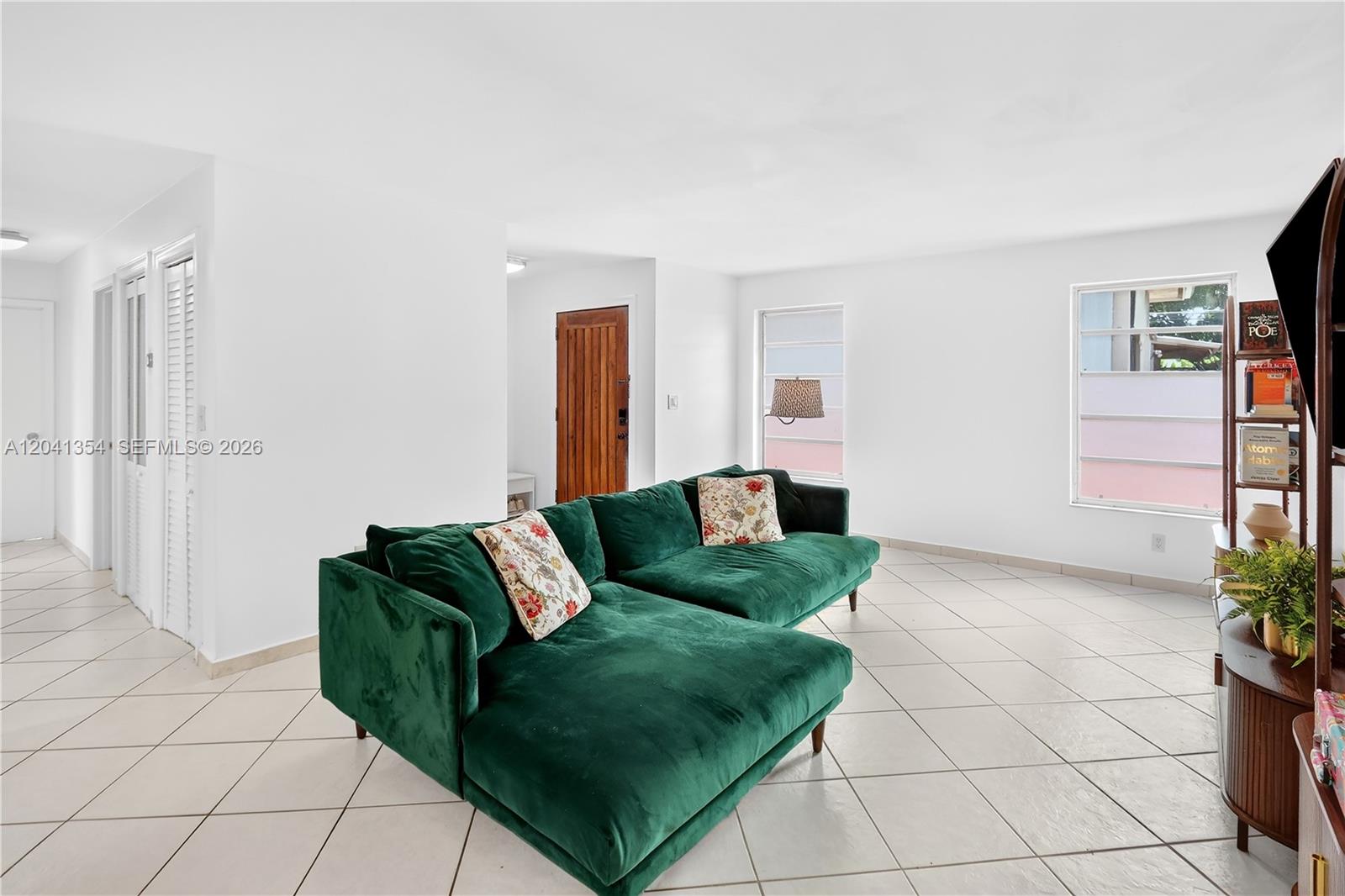A living room features a green velvet sectional sofa, white walls, and light tile flooring — 3210 NW 19th St, Miami FL 33125, MIAMI, FL