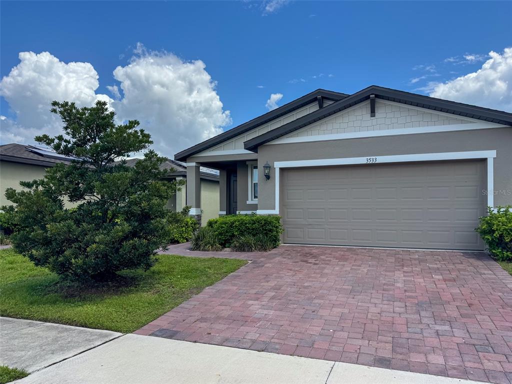 A single-story house with a brick paver driveway and a two-car garage — 3533 BROADWING BOULEVARD, POINCIANA, FL