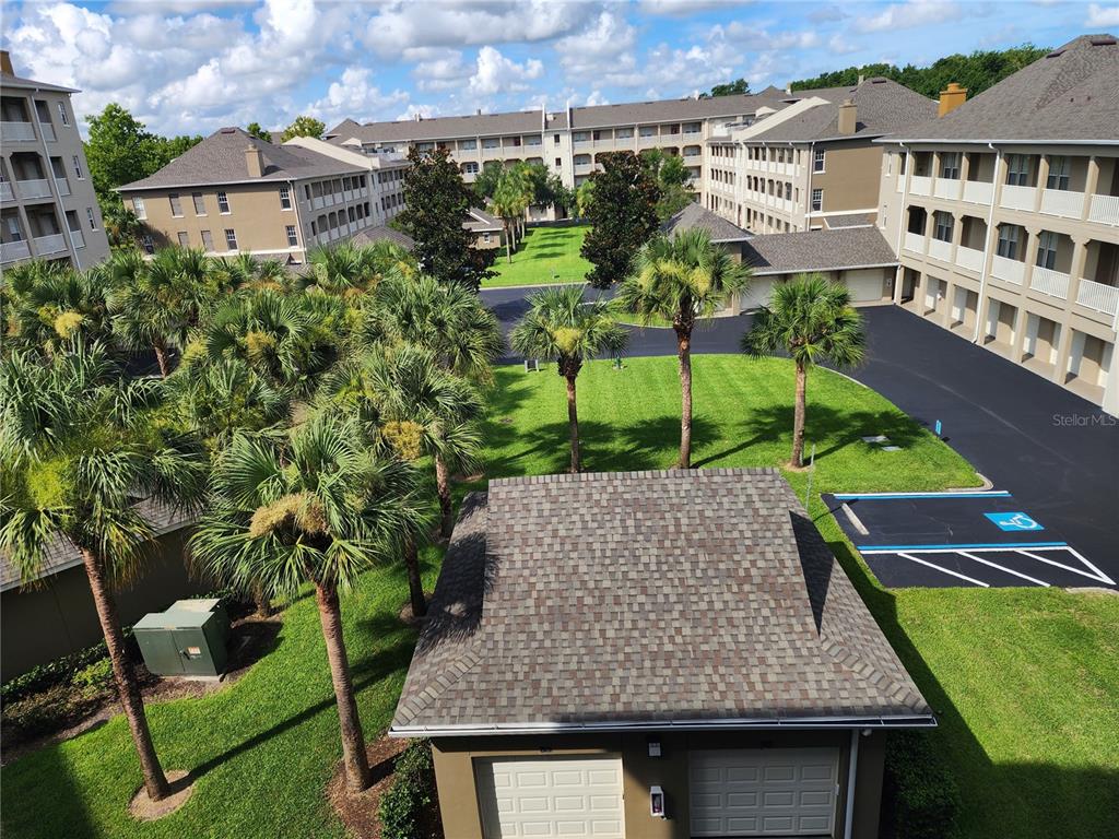 An elevated view of a residential complex with palm trees, green lawns, and parking areas — 1211 STONECUTTER DRIVE UNIT 403, CELEBRATION, FL