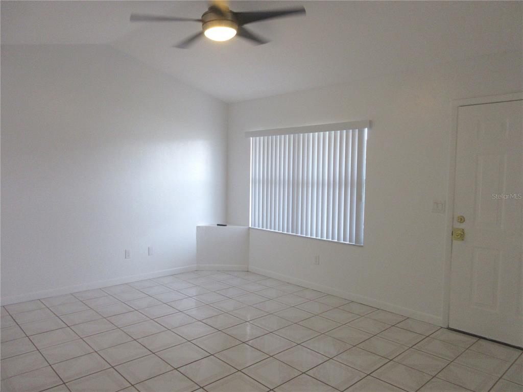 A room with white walls, tiled flooring, a ceiling fan, and a window with blinds — 14131 SW 30TH TERRACE ROAD, OCALA, FL