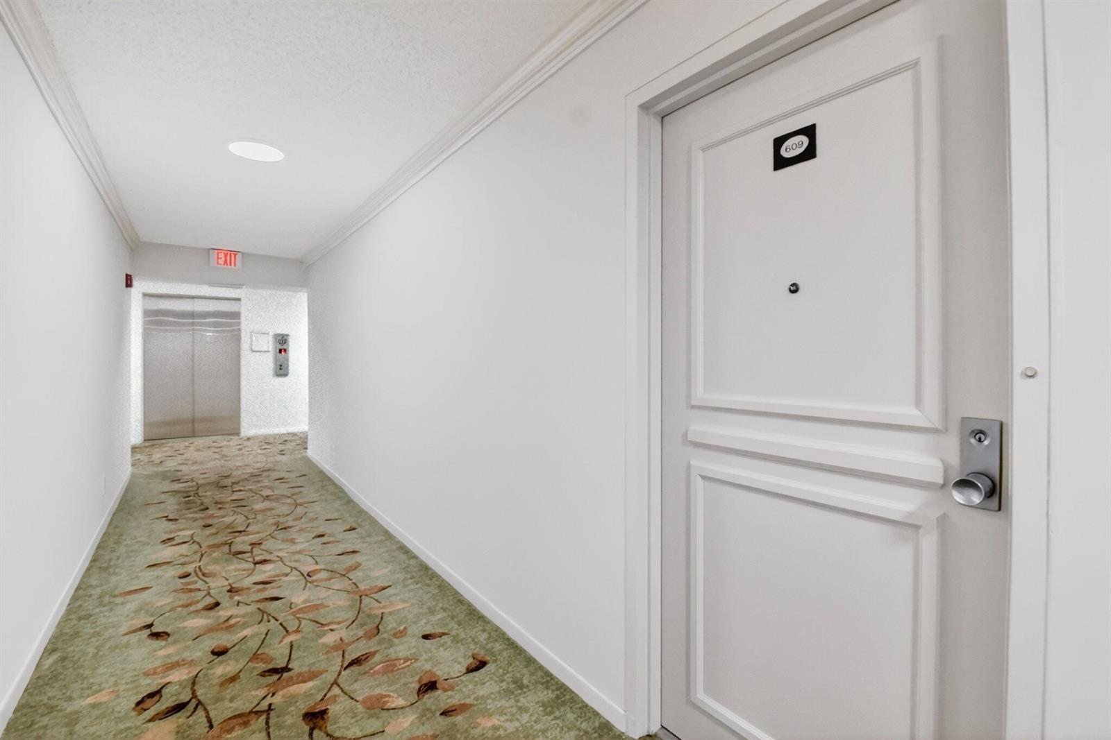 A white door labeled 609 opens into a hallway with patterned carpet and an elevator — 3589 S Ocean Boulevard # 609, South Palm Beach FL 33480, SOUTH PALM BEACH, FL