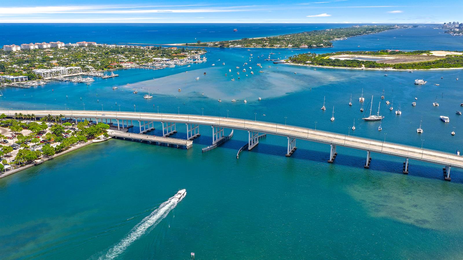 An aerial view shows a bridge spanning a waterway with boats and coastal land nearby — 176 E 24th Street, Riviera Beach FL 33404, RIVIERA BEACH, FL