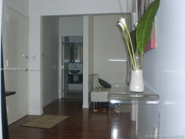 A hallway leads to a bathroom with a vessel sink and dark wood flooring — 577 NE 62 STREET # 2, Miami FL 33138, MIAMI, FL