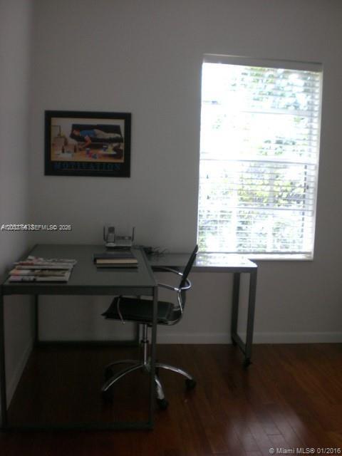 A home office features a glass desk, a rolling chair, and a window with blinds — 577 NE 62 STREET # 2, Miami FL 33138, MIAMI, FL