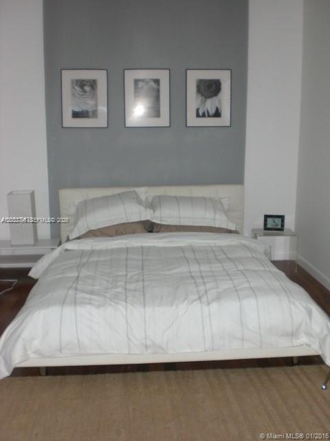 A bedroom features a white bed against a gray accent wall with three framed prints — 577 NE 62 STREET # 2, Miami FL 33138, MIAMI, FL