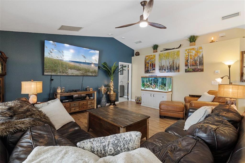 A living room features a dark blue accent wall, leather furniture, and a large aquarium — 3953 VEHLIN STREET, NORTH PORT, FL