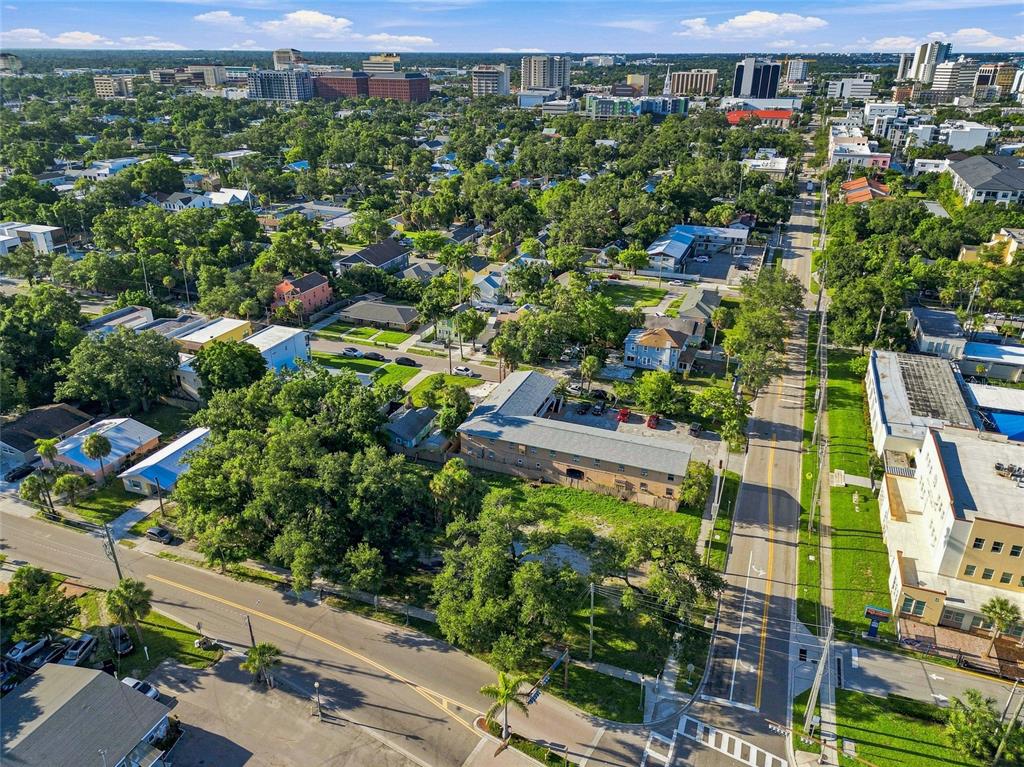 An aerial view shows a city neighborhood with buildings, parking lots, and surrounding trees — 918 ORANGE AVENUE, SARASOTA, FL