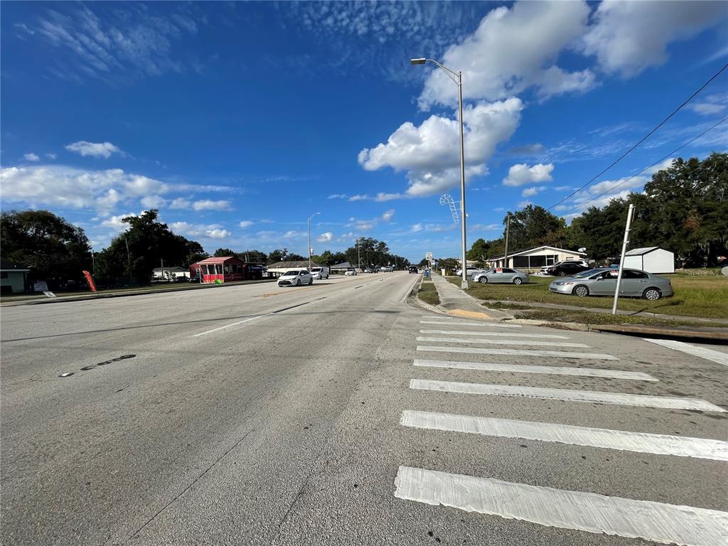A view of a paved road with a crosswalk and surrounding residential buildings — 7 4TH STREET SE, FORT MEADE, FL