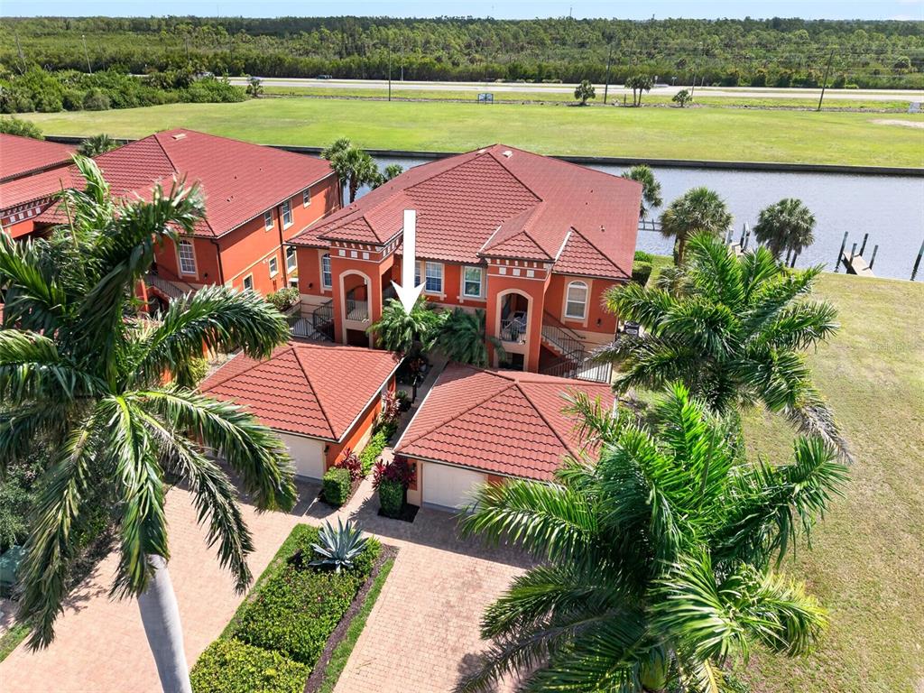 An aerial view shows a multi-story residential building with red tile roofs and palm trees — 3500 MONDOVI COURT UNIT 1011, PUNTA GORDA, FL