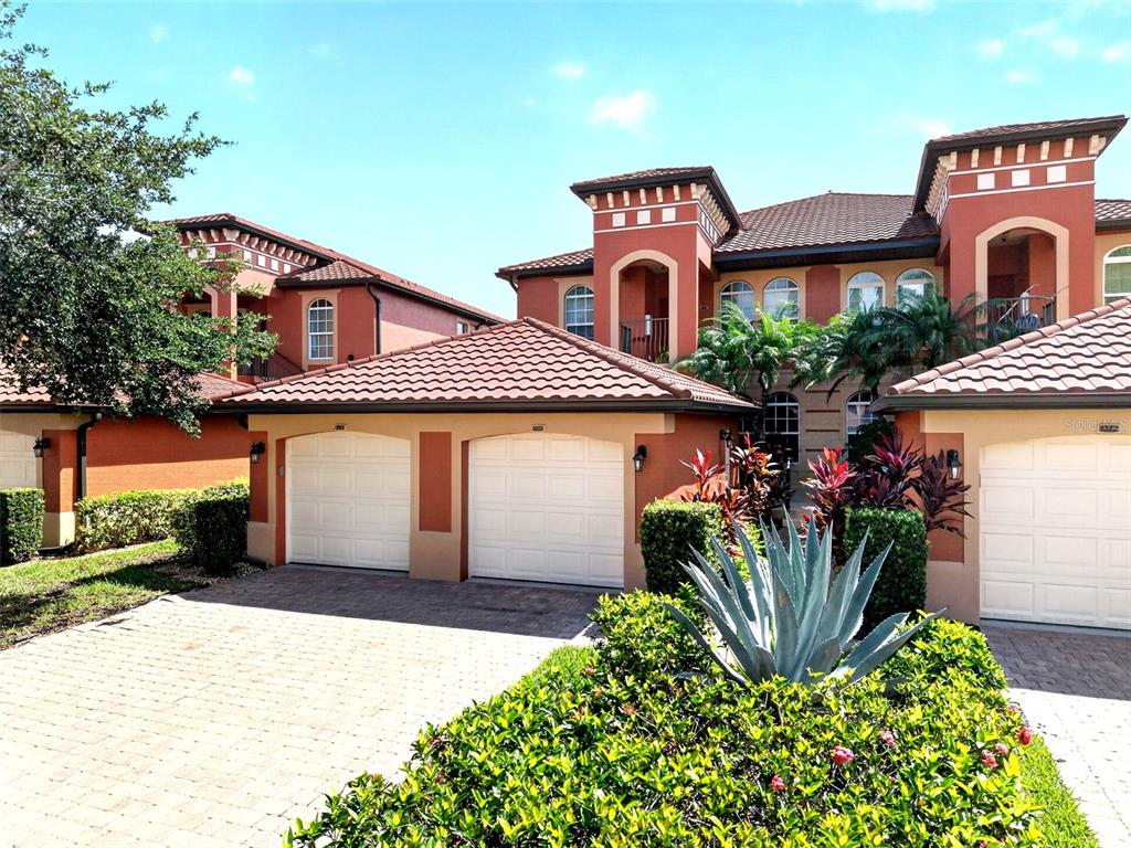 A multi-story Mediterranean-style home features a three-car garage and a paved driveway — 3500 MONDOVI COURT UNIT 1011, PUNTA GORDA, FL