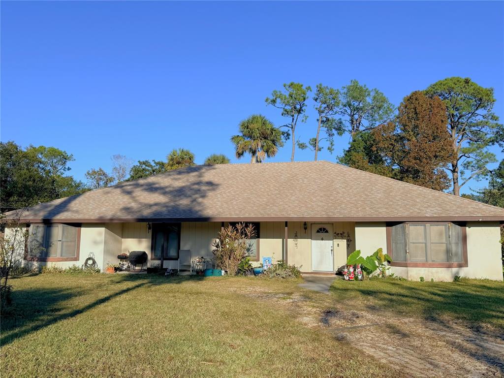 A single-story house with a beige exterior, a hip roof, and a front yard — 1627 DECATUR AVENUE, HOLLY HILL, FL