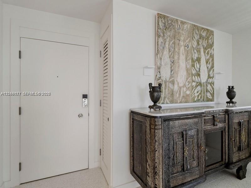 A white door stands next to a dark wood sideboard topped with two decorative urns — 5 Island Ave # 8H, Miami Beach FL 33139, MIAMI BEACH, FL