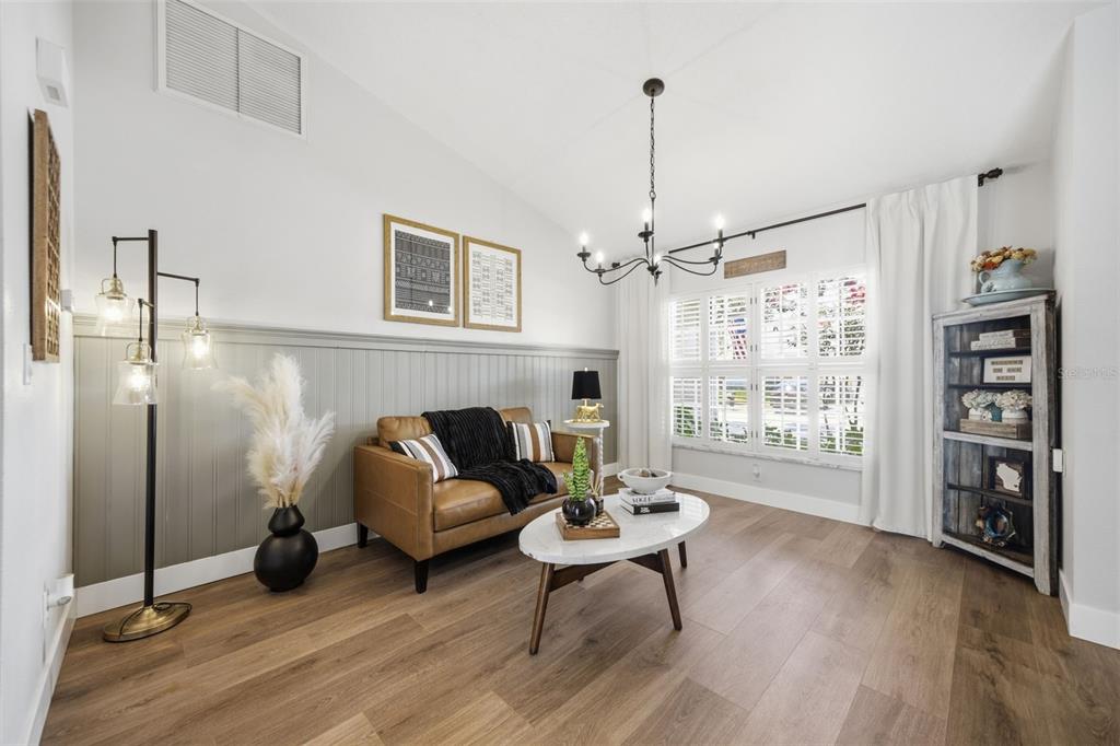 A living room features a tan leather sofa, a marble coffee table, and wood-paneled walls — 2409 ARBORWOOD DRIVE, VALRICO, FL