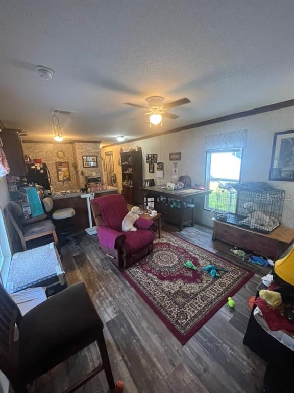 This open-concept living area features wood-look flooring, a red area rug, and a kitchen island — 11347 NW 12TH LANE, OCALA, FL