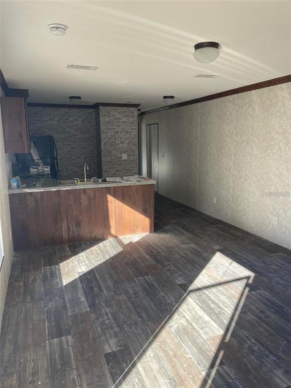 A kitchen with a wooden island and faux brick backsplash opens into a living area — 11347 NW 12TH LANE, OCALA, FL