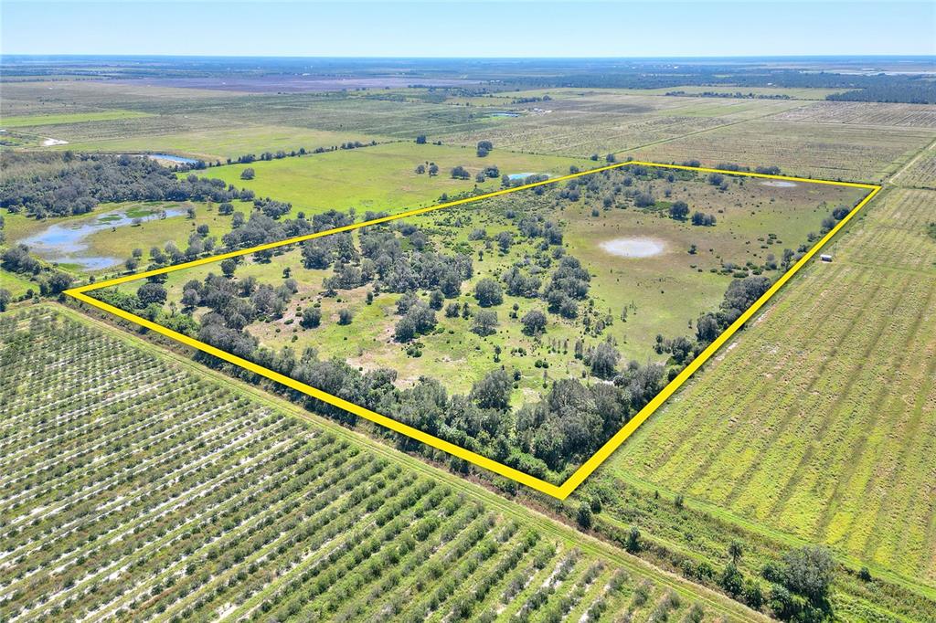 An aerial view shows a rectangular plot of land outlined in yellow amidst rural fields — 46891 FARABEE ROAD, PUNTA GORDA, FL