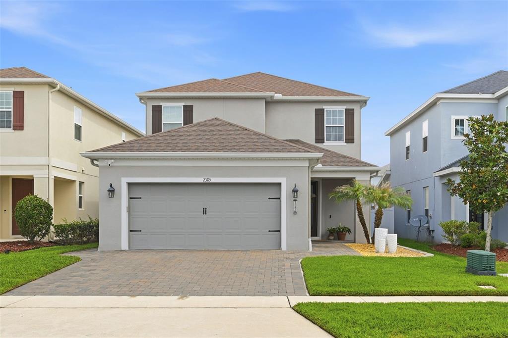 A two-story suburban house with a gray exterior, a two-car garage, and a paved driveway — 2385 DAMMAR STREET, ORLANDO, FL