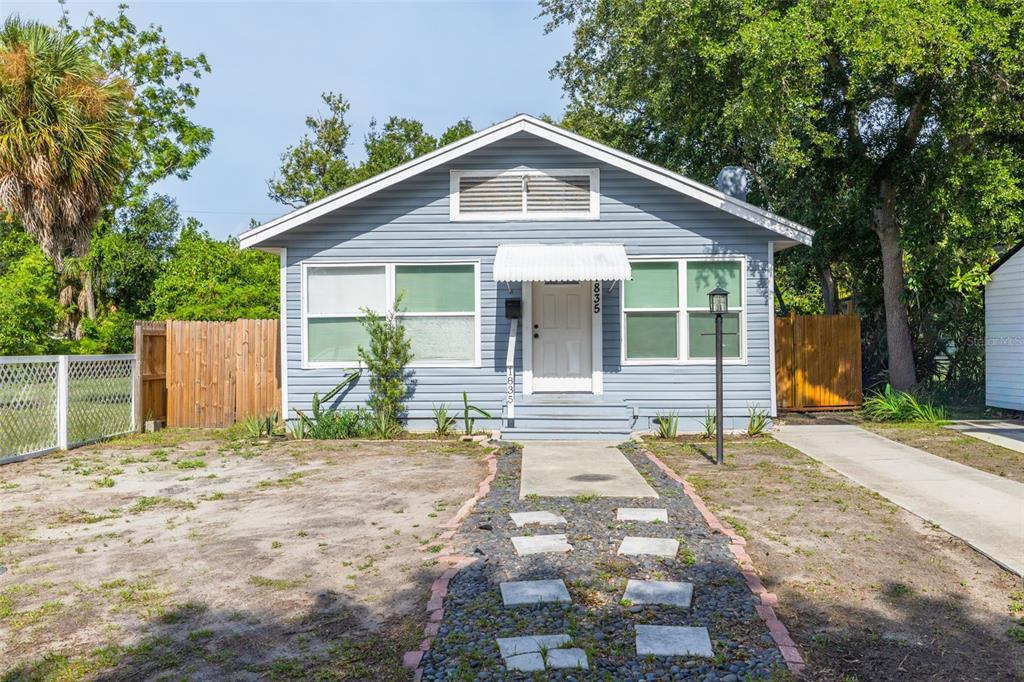 A light blue, single-story house features a front walkway with stone pavers and gravel — 1835 47TH STREET S, ST PETERSBURG, FL
