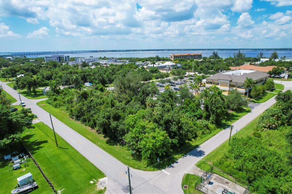 An aerial view shows a vacant, tree-covered lot situated between two paved roads near water — 1010 LAVILLA ROAD, PUNTA GORDA, FL