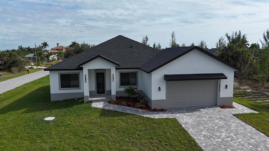 An exterior view of a single-story house with a paved driveway and a two-car garage — 10426 LIVE OAK ROAD, PORT CHARLOTTE, FL