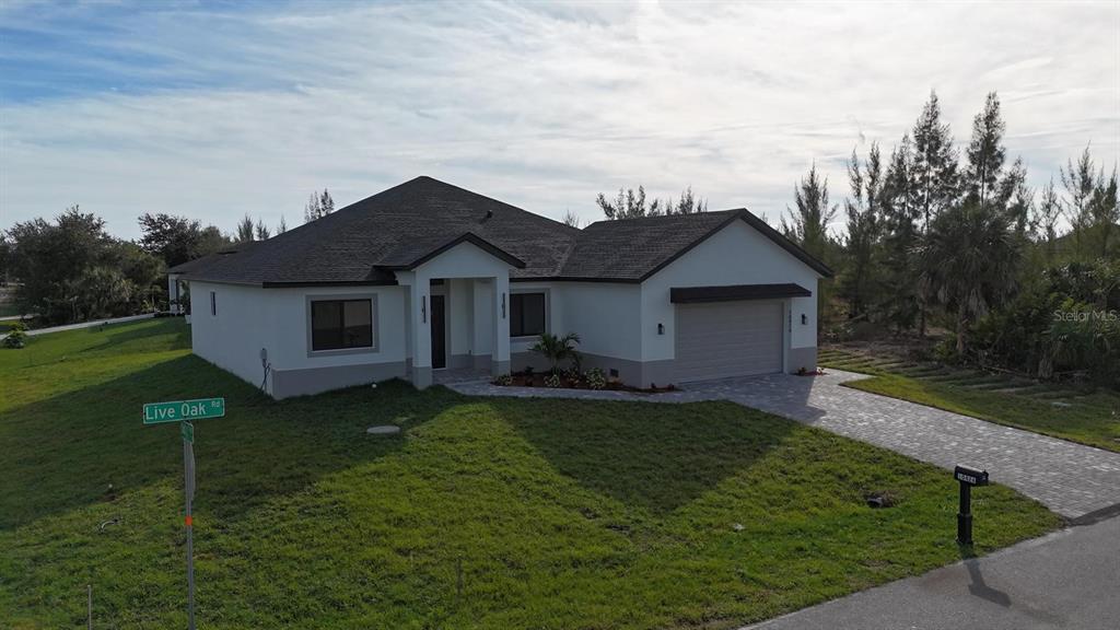 A single-story house with a paved driveway, a two-car garage, and a grassy front yard — 10426 LIVE OAK ROAD, PORT CHARLOTTE, FL
