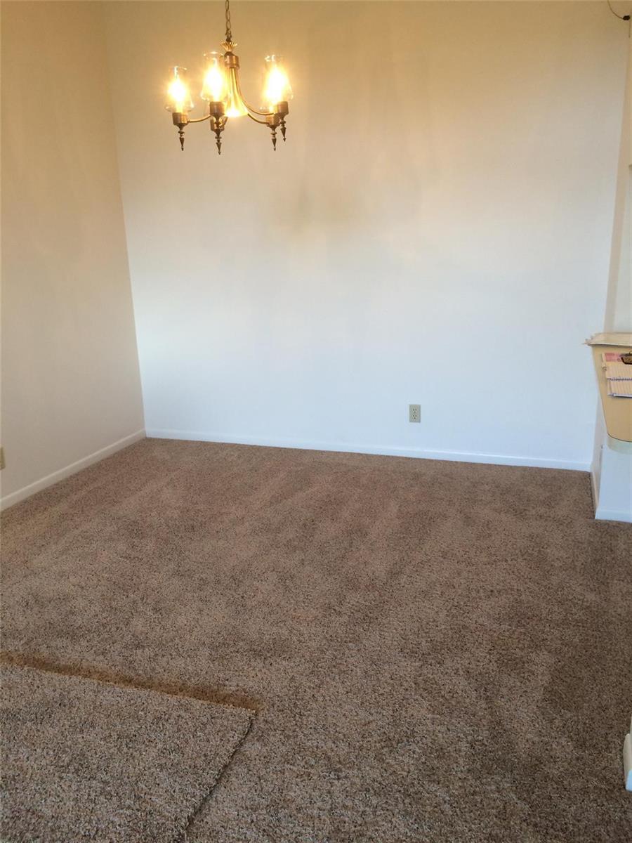An empty dining area features beige carpeting, white walls, and a traditional brass chandelier — 209 Foxtail Drive # 3, FL 33415, FL