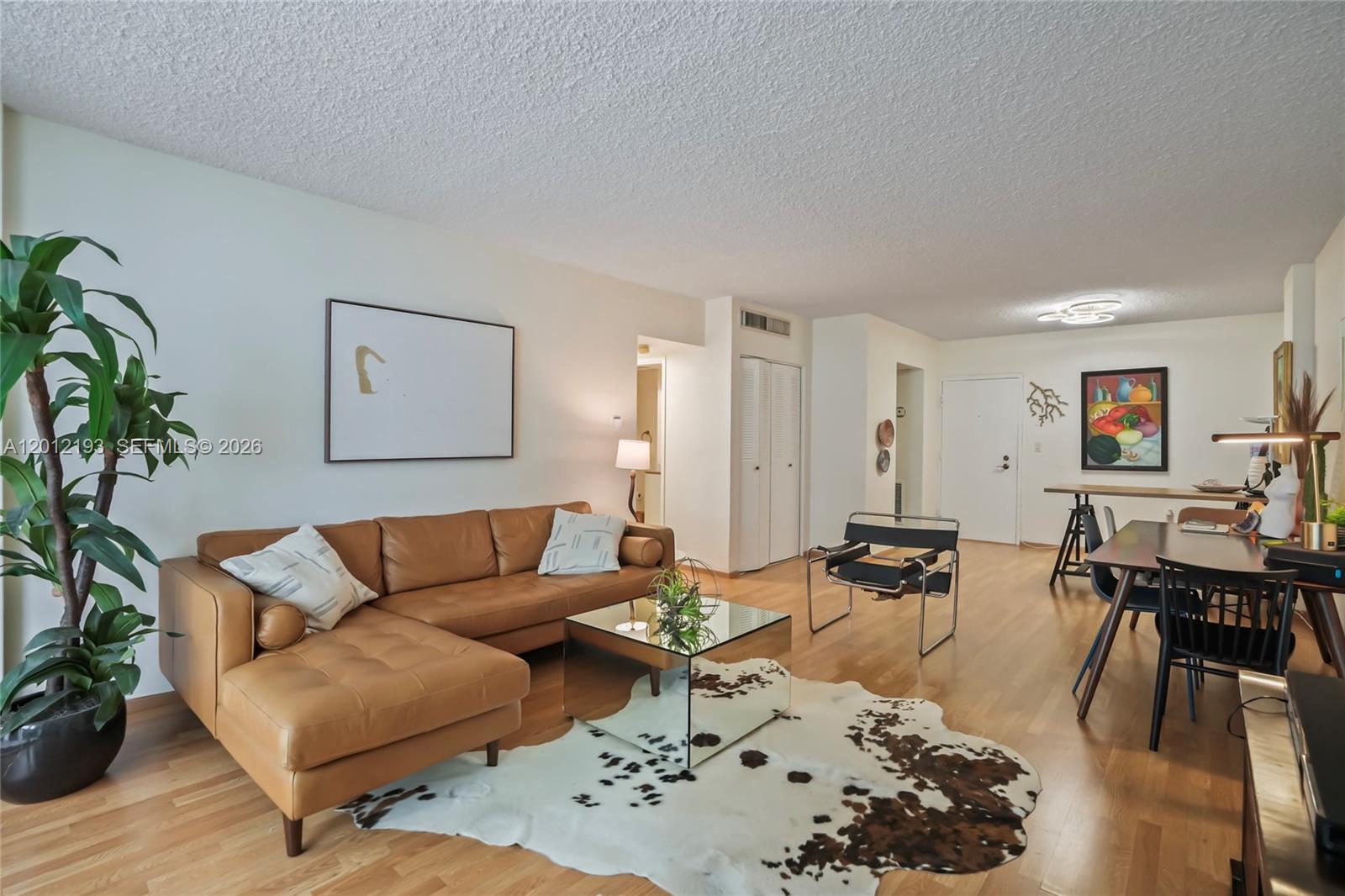 A living room features a tan leather sectional, mirrored coffee table, and cowhide rug — 800 West Ave # 738, Miami Beach FL 33139, MIAMI BEACH, FL