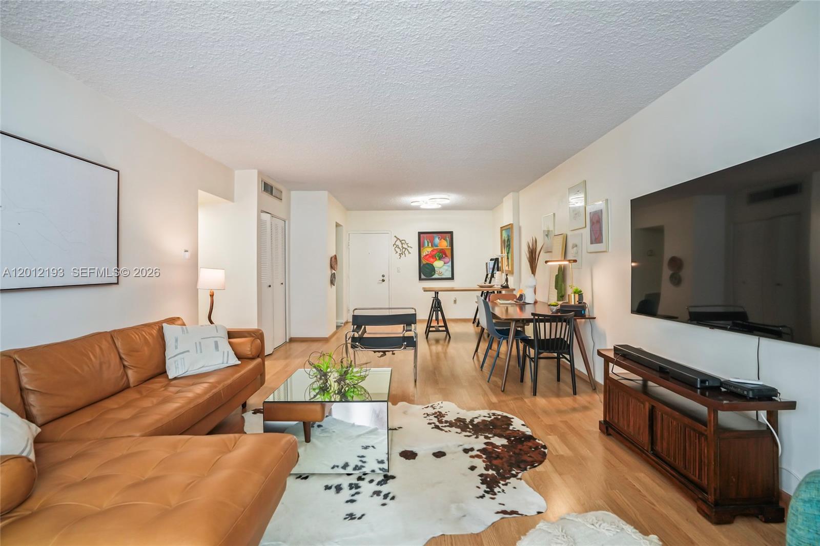 A living room features a leather sectional, a mirrored coffee table, and a dining area — 800 West Ave # 738, Miami Beach FL 33139, MIAMI BEACH, FL