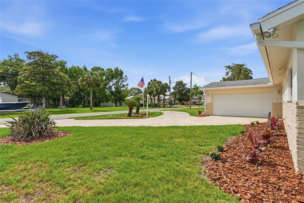 A view of a house exterior featuring a concrete driveway, garage, and landscaped front yard — 1401 SE PARADISE AVENUE, CRYSTAL RIVER, FL