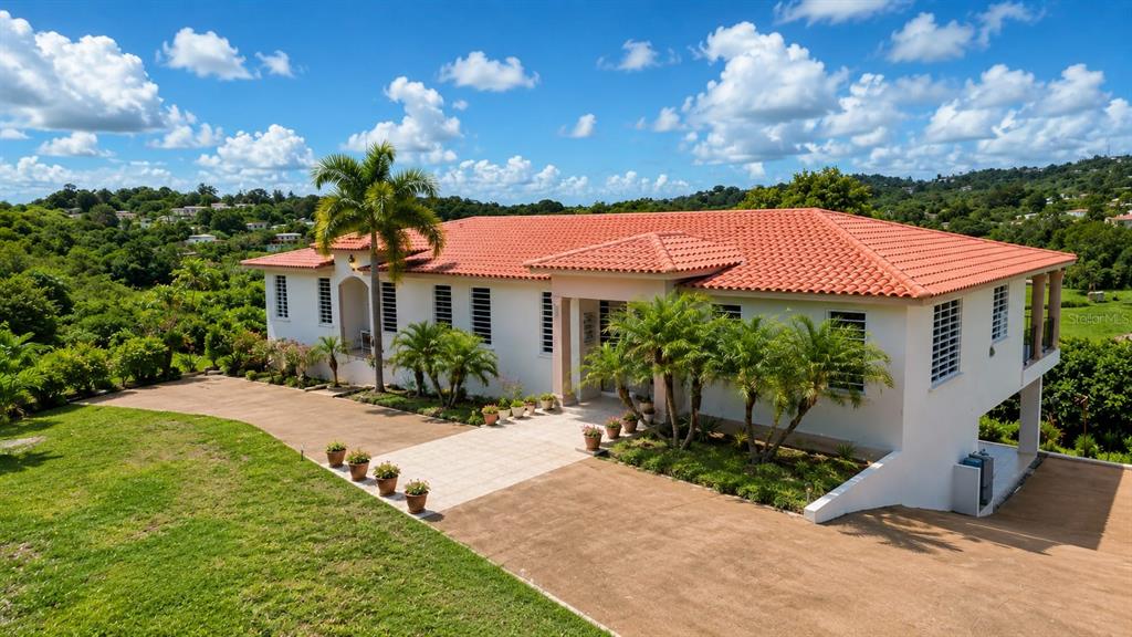 A white house with a red tile roof sits on a grassy hill — Car 416 km 2.3 PIEDRAS BLANCAS, AGUADA, PR