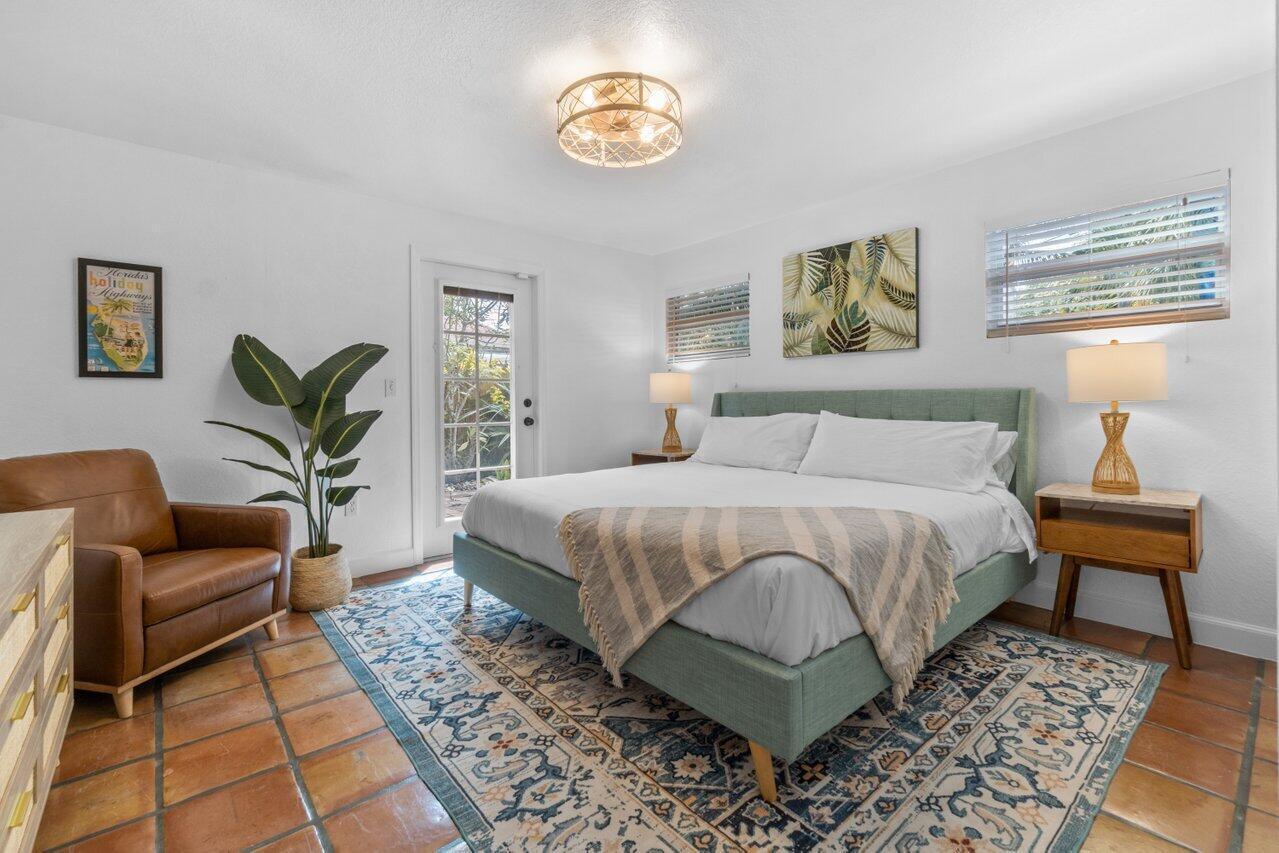 A bedroom features a green upholstered bed, a leather armchair, and a patterned area rug — 1911 Parker Avenue, West Palm Beach FL 33401, WEST PALM BEACH, FL