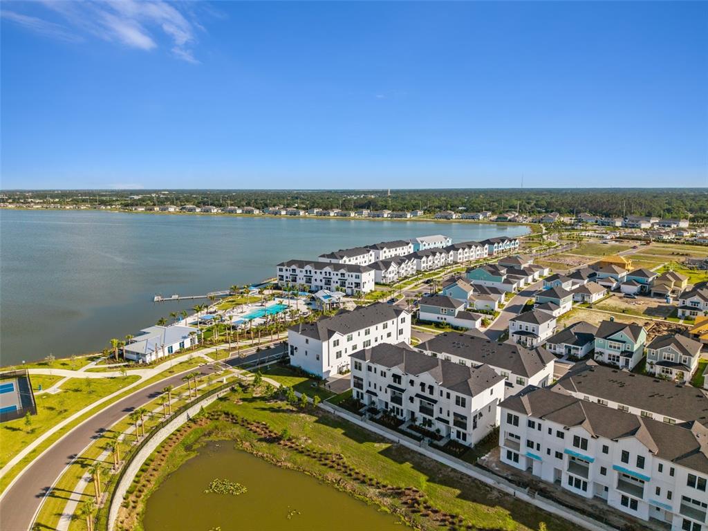An aerial view shows a modern residential community situated next to a large lake — 7244 SUTTON LANE, SARASOTA, FL