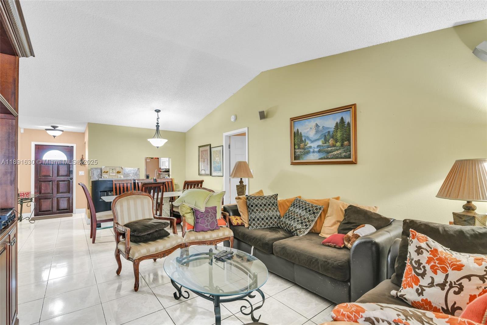 A living room with tile floors, a vaulted ceiling, and a dark brown sofa — 13520 SW 116th Ct, Miami FL 33176, MIAMI, FL