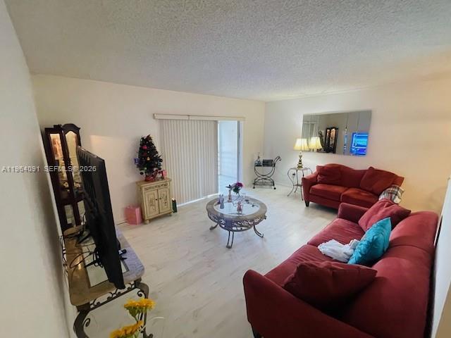 A living room features a red sofa, a glass coffee table, and a television — 5180 E Sabal Palm Blvd # 235, Tamarac FL 33319, TAMARAC, FL