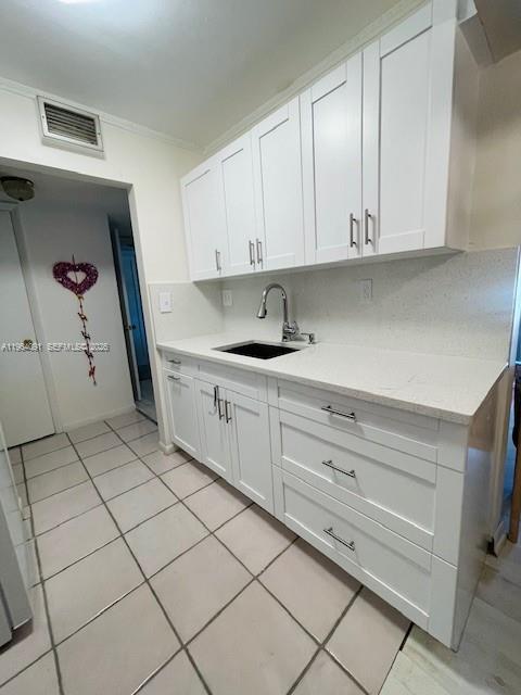 A kitchen features white cabinets, a light countertop, a sink, and tiled flooring — 5180 E Sabal Palm Blvd # 235, Tamarac FL 33319, TAMARAC, FL