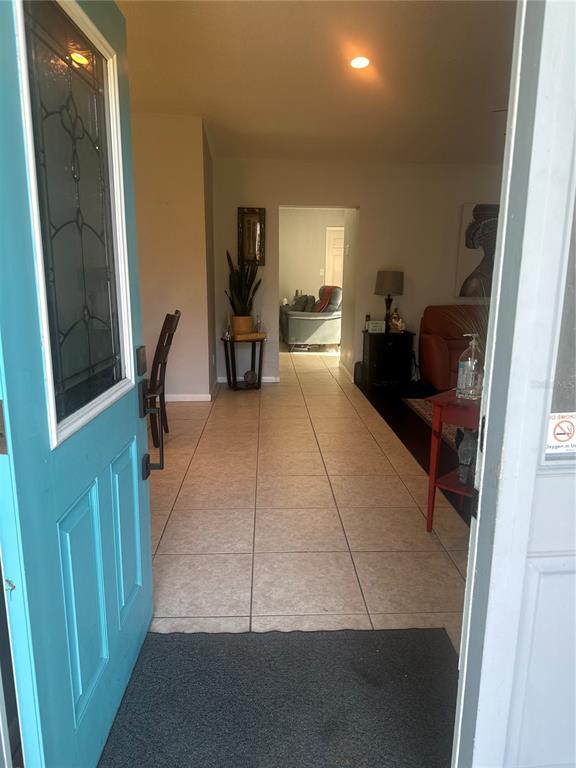 An entryway opens into a tiled living area with a dining space and a sofa — 2527 10TH AVENUE S, ST PETERSBURG, FL