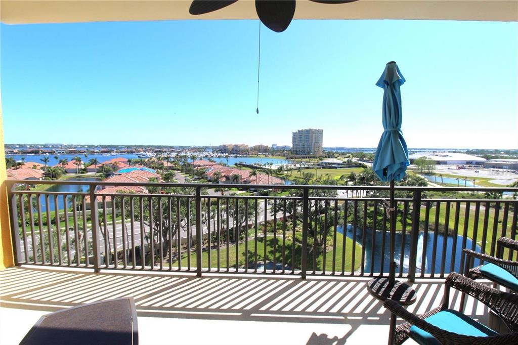 A balcony with a metal railing overlooks a residential area, a lake, and distant buildings — 501 HABEN BOULEVARD UNIT 704, PALMETTO, FL