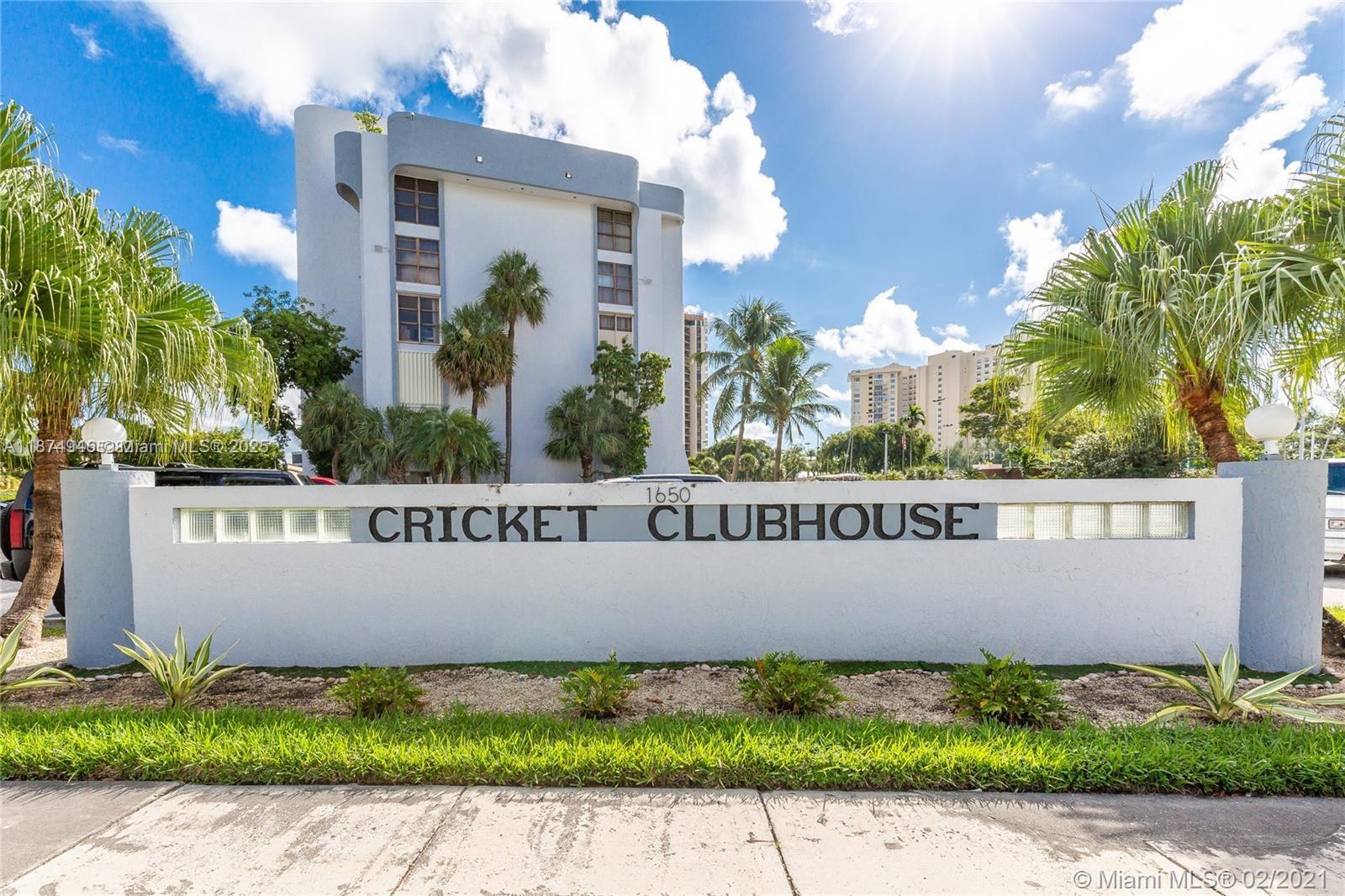 A white wall with the text Cricket Clubhouse stands in front of a multi-story building — 1650 NE 115th St # 403, Miami FL 33181, MIAMI, FL