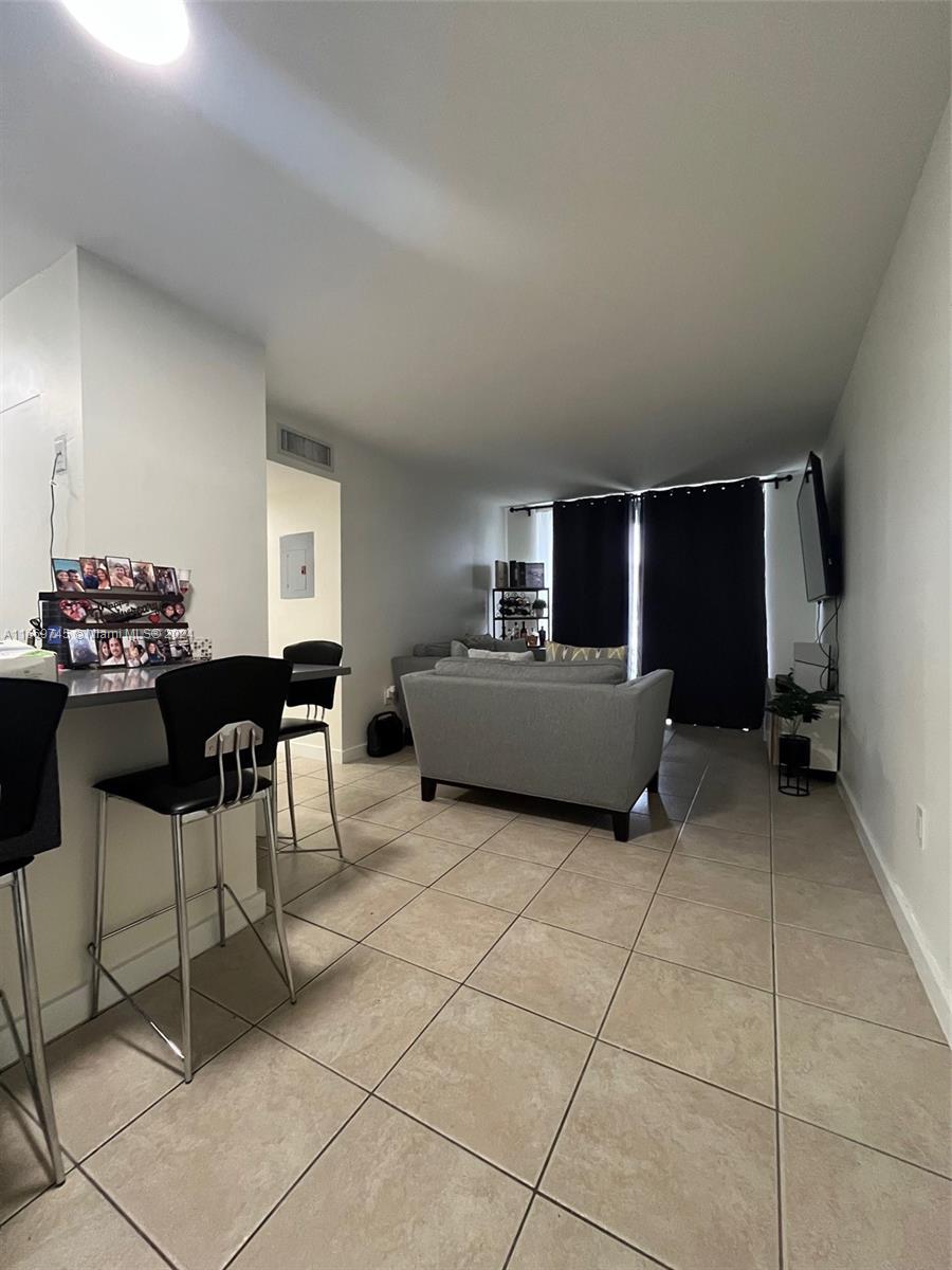 A living room with tile flooring, a breakfast bar, and a gray sofa — 8075 NW 7th St # 109, Miami FL 33126, MIAMI, FL