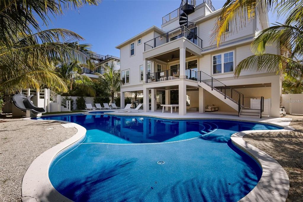 A multi-story house with a pool, spiral staircase, and elevated deck in a backyard setting — 119 MCKINLEY DRIVE, SARASOTA, FL