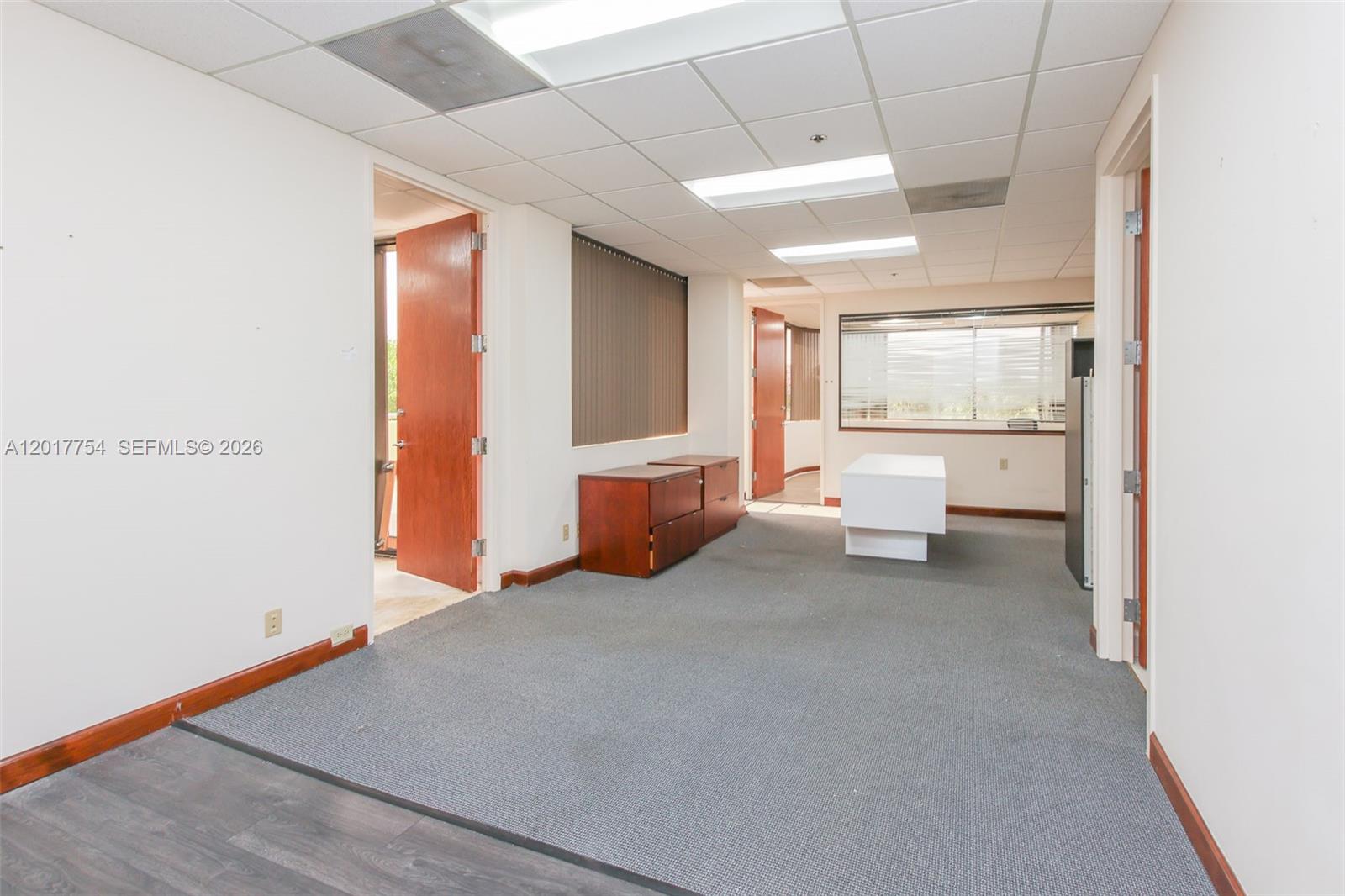 An office space features gray carpeting, white walls, drop ceilings, and two wooden doors — 1900 Glades Rd # 245, Boca Raton FL 33431, BOCA RATON, FL