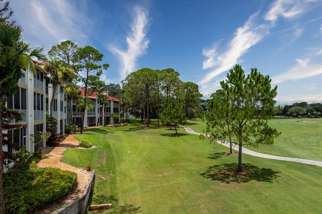 Exterior view of a multi-story apartment building with screened balconies and a red tile roof — 459 HAMPTONCREST CIRCLE UNIT 103, LAKE MARY, FL