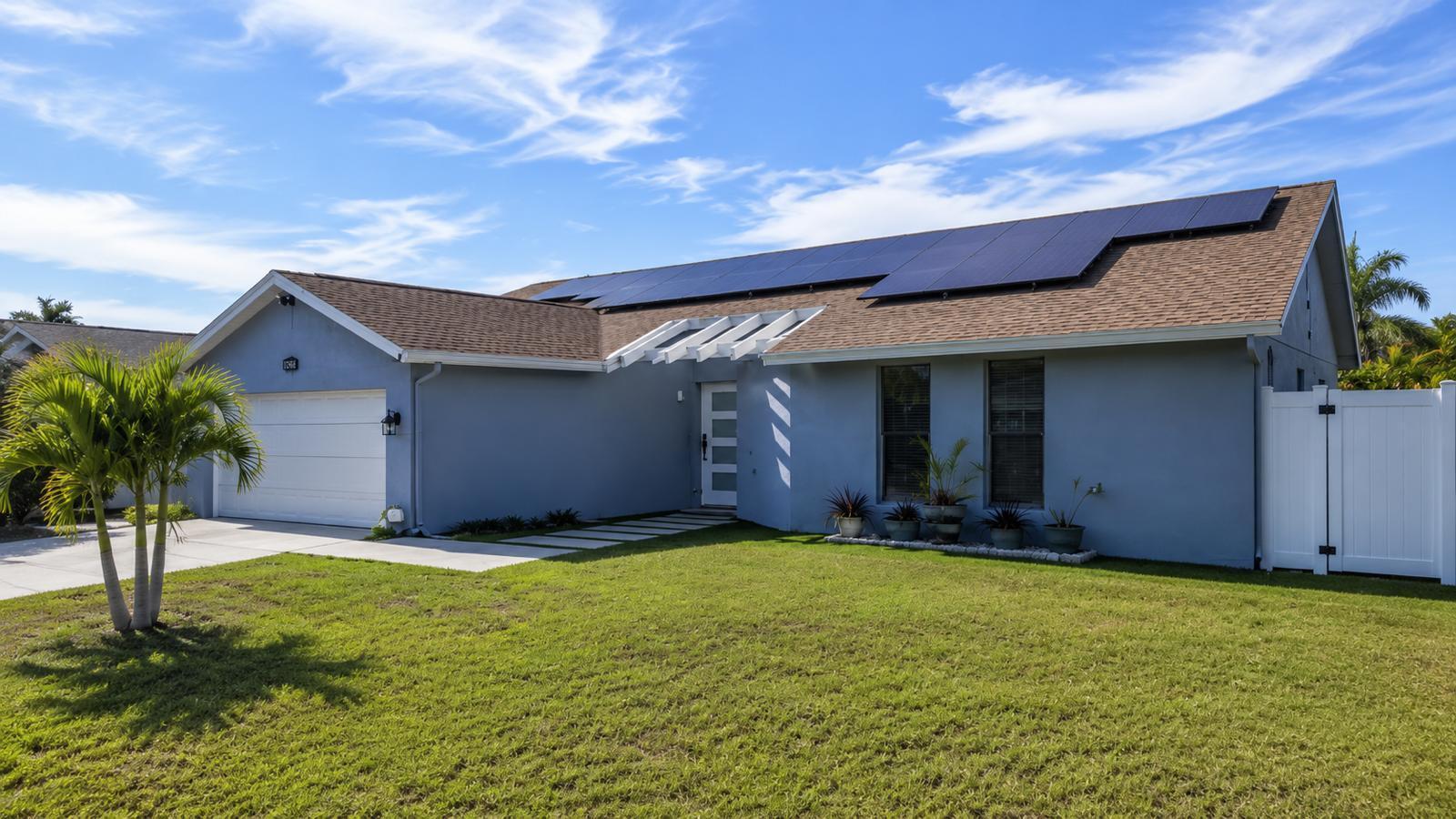 A single-story blue house with a white garage, solar panels, and a palm tree — 23287 SW 60th Avenue, Boca Raton FL 33428, BOCA RATON, FL