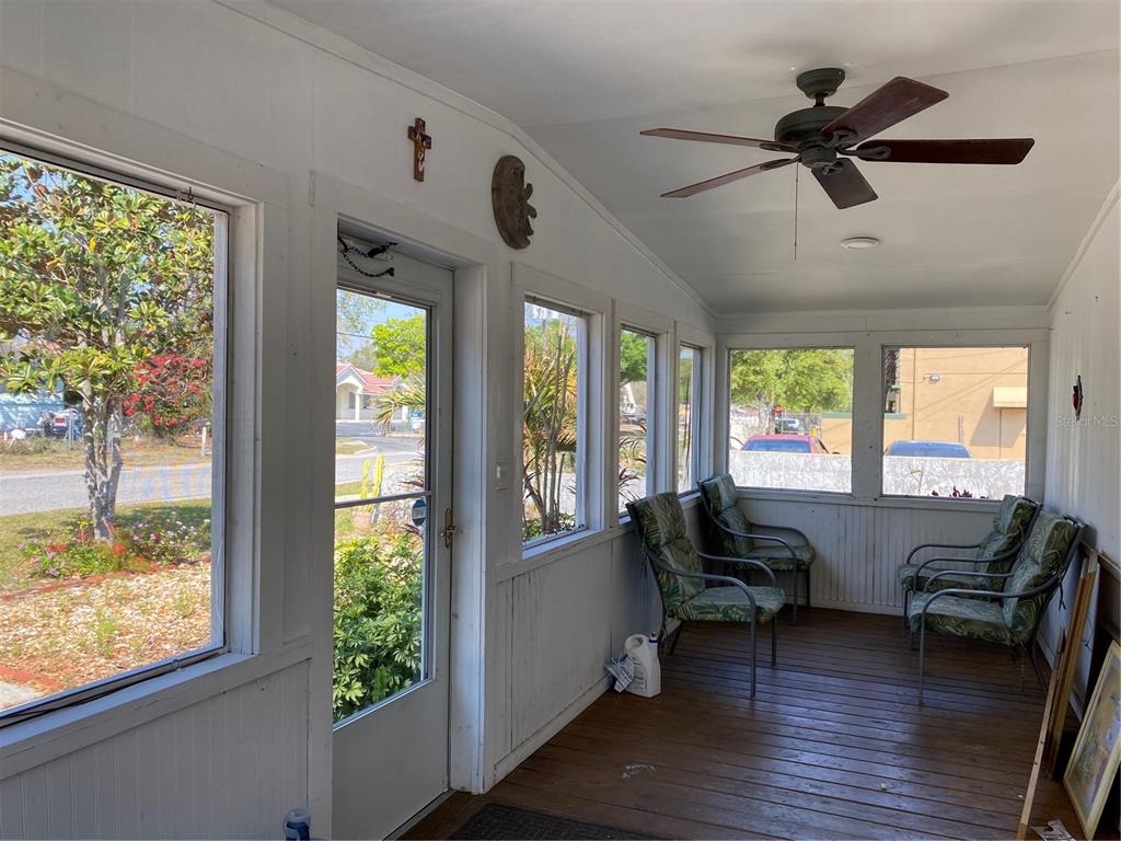 A sunroom features wood flooring, large windows, a ceiling fan, and several patio chairs — 313 S OBSERVATORY DRIVE, ORLANDO, FL